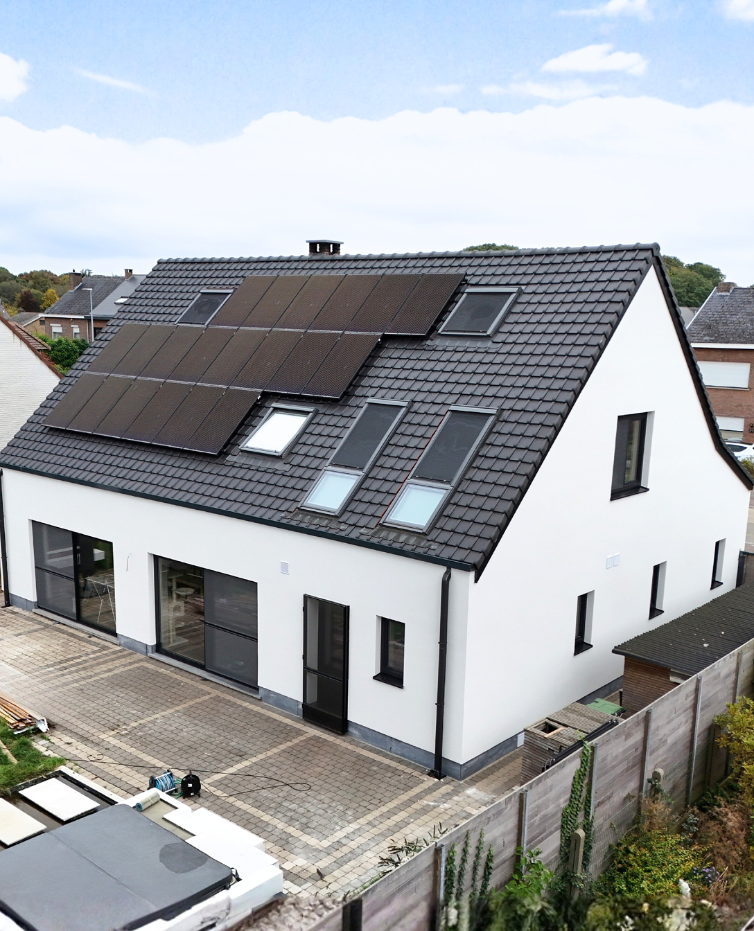 Woning met een nieuwe witte gevel en een donker dak met zonnepanelen