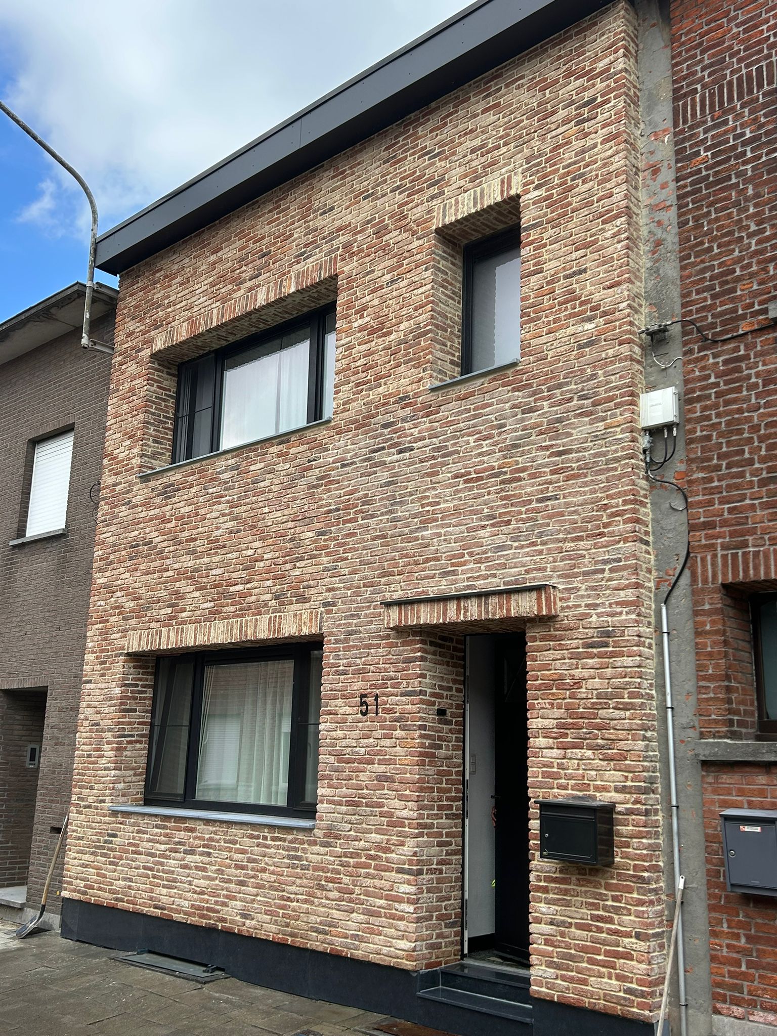 Rijwoning met een nieuwe gevel in steenstrips