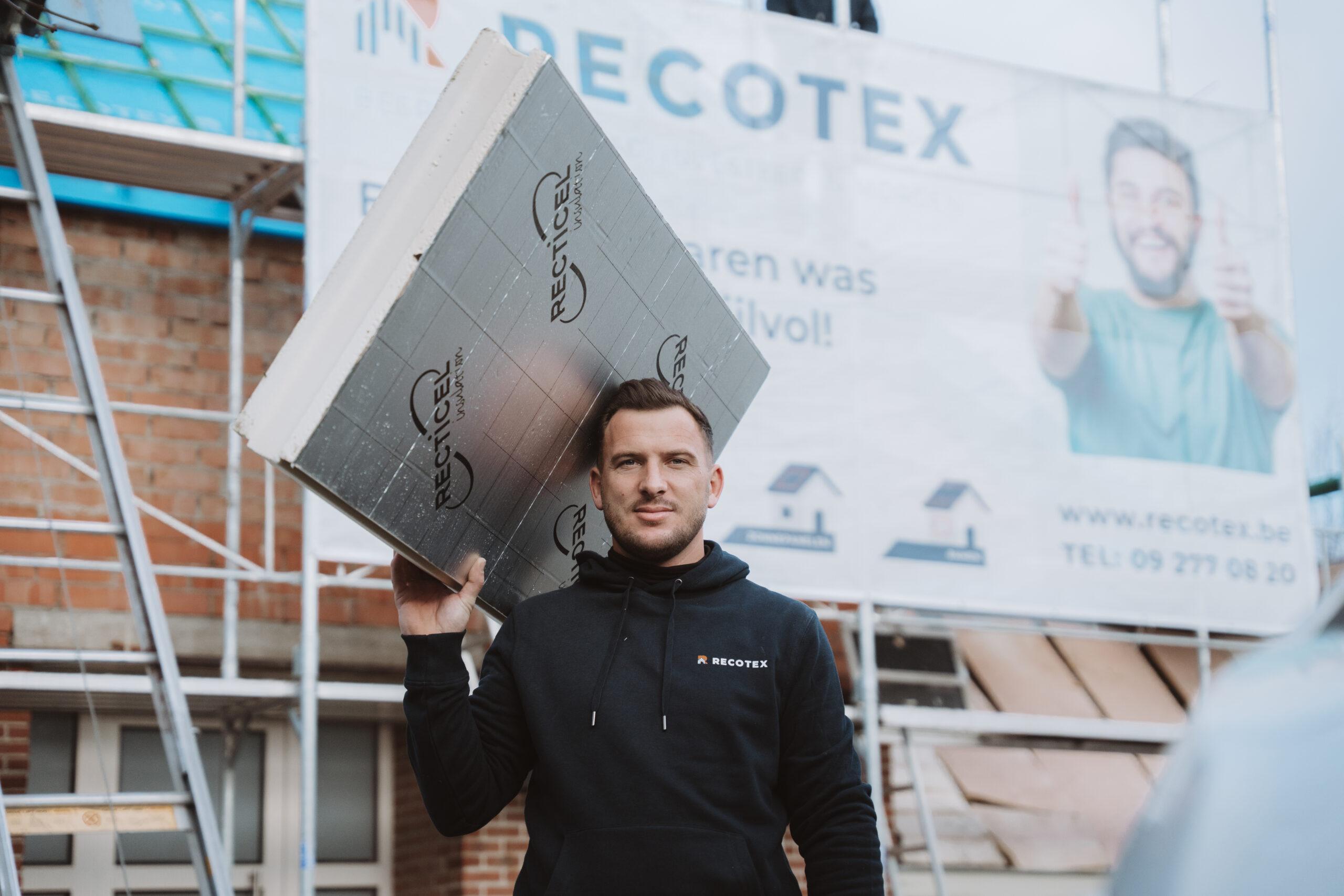 Een medewerker van Recotex met een isolatieplaat op de werf