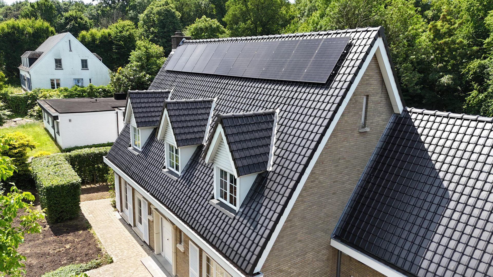 Volledig dakvlak met zonnepanelenrij en dakkapellen na de dakwerken in Herent