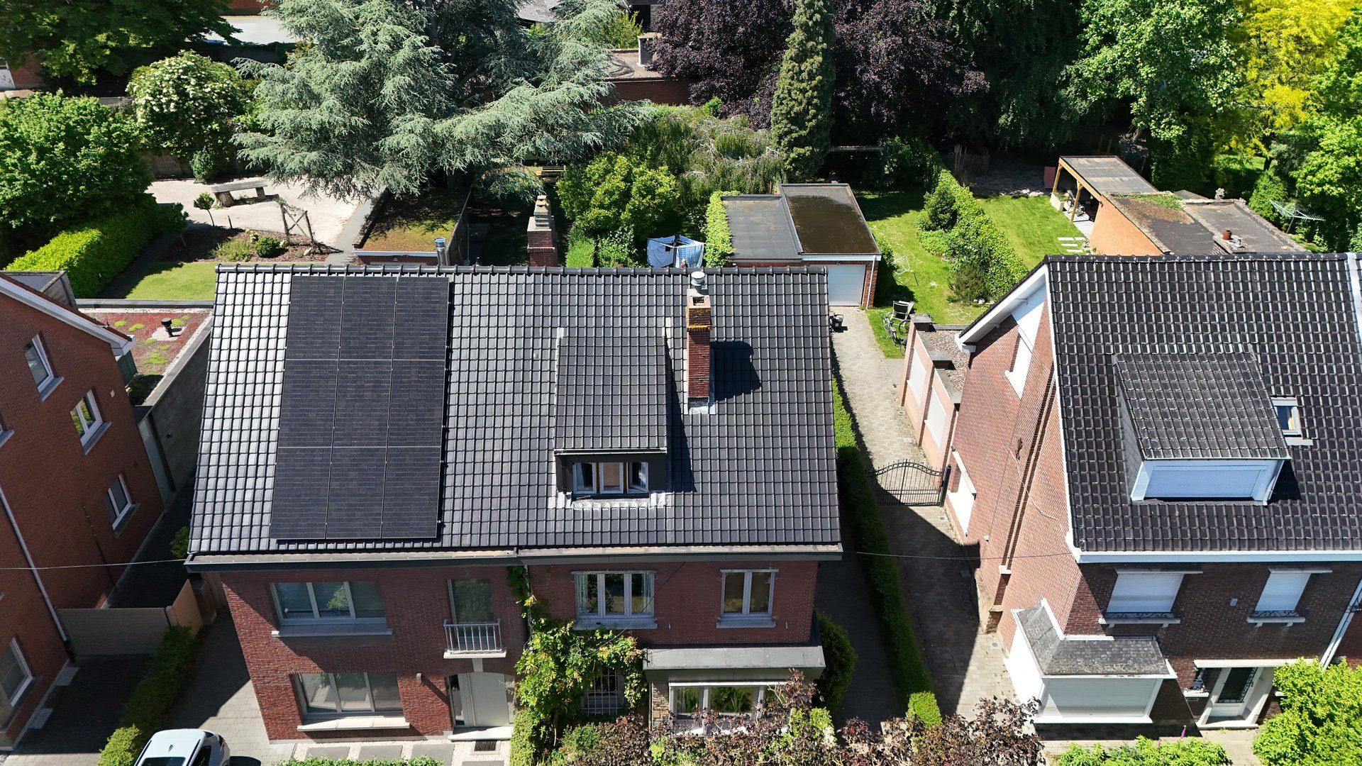 Hoog dronebeeld van het vernieuwde dak in Mortsel met groene omgeving