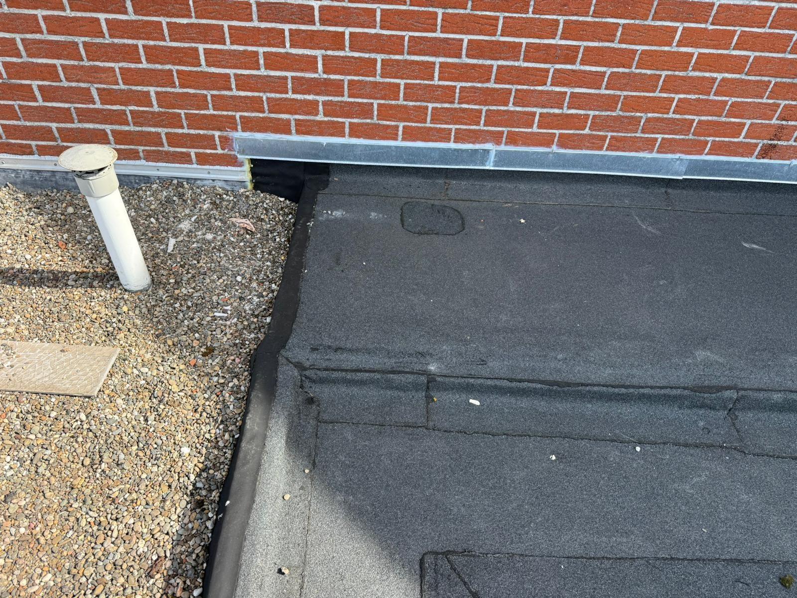 Verluchtingspijp met zinken slab op het vernieuwde plat dak in Ninove